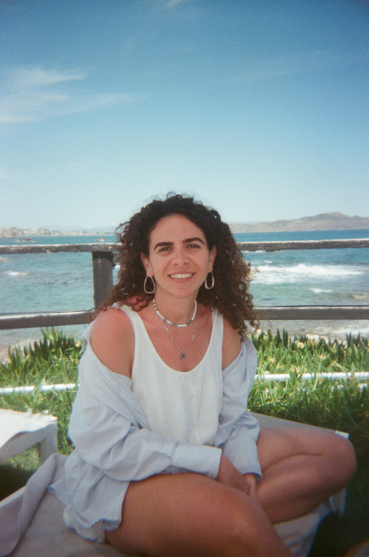 Portrait of Yula sitting outdoors by the water
